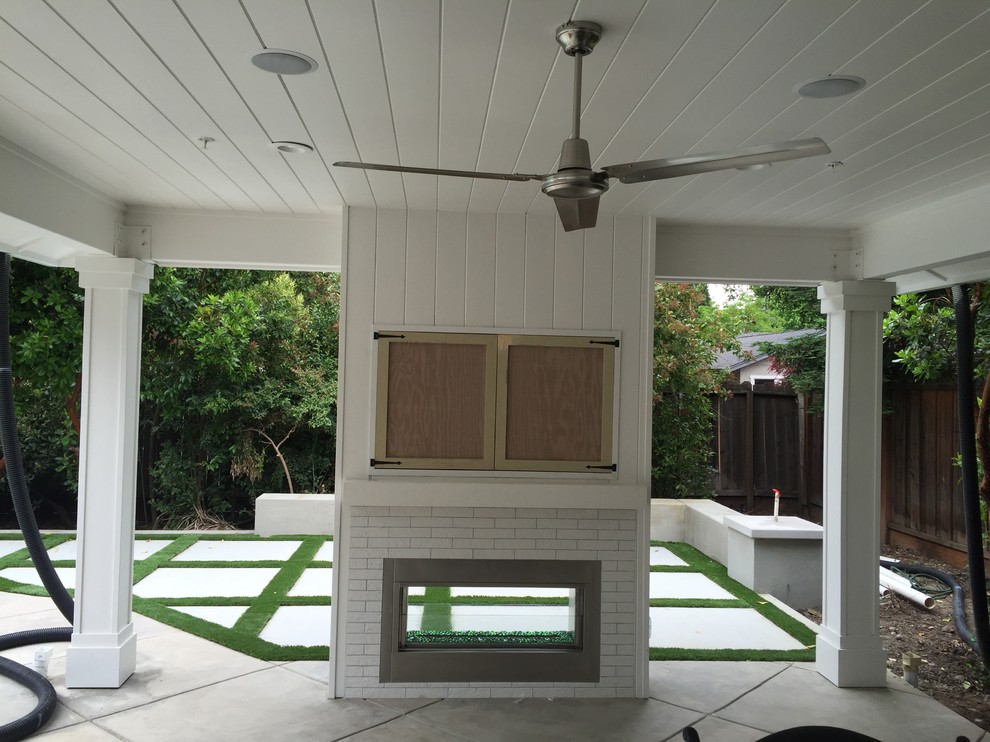 Cette image montre une terrasse arrière traditionnelle de taille moyenne avec un foyer extérieur, des pavés en béton et un gazebo ou pavillon.