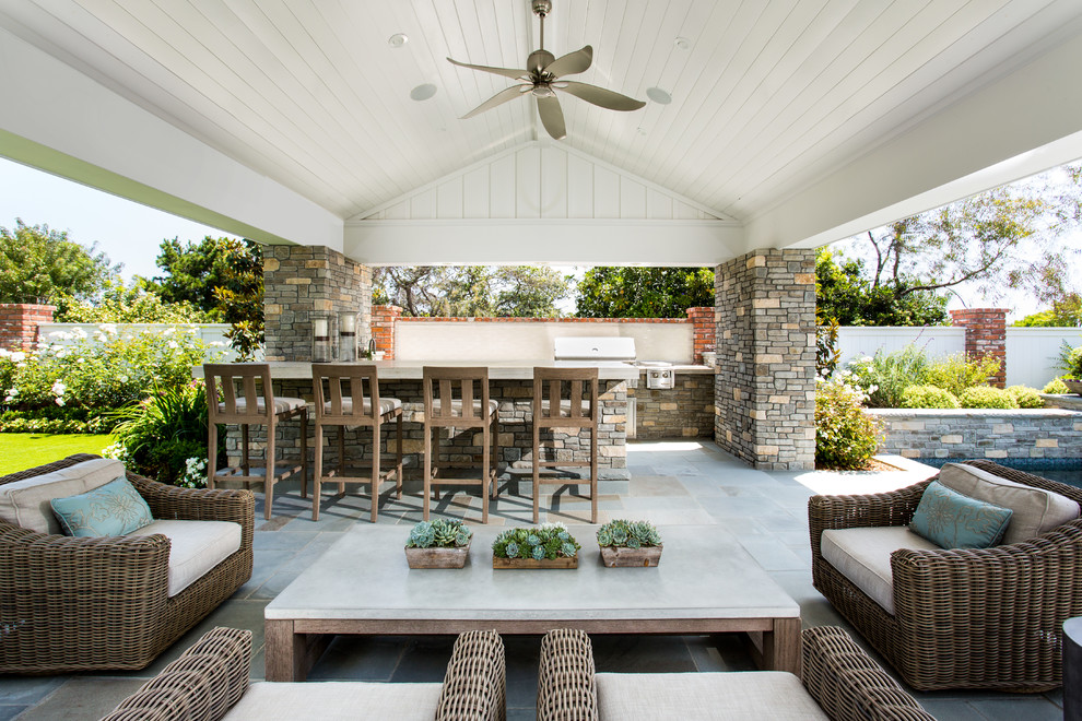 Foto de patio clásico grande en patio trasero y anexo de casas con cocina exterior y adoquines de piedra natural