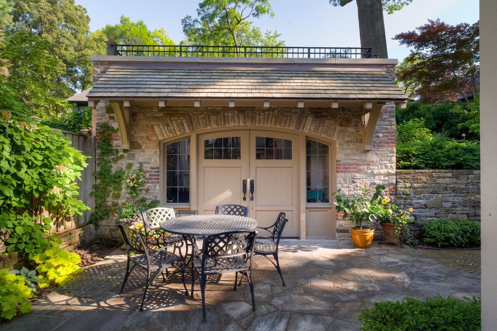 Idee per un patio o portico tradizionale di medie dimensioni e dietro casa con pavimentazioni in pietra naturale e un tetto a sbalzo