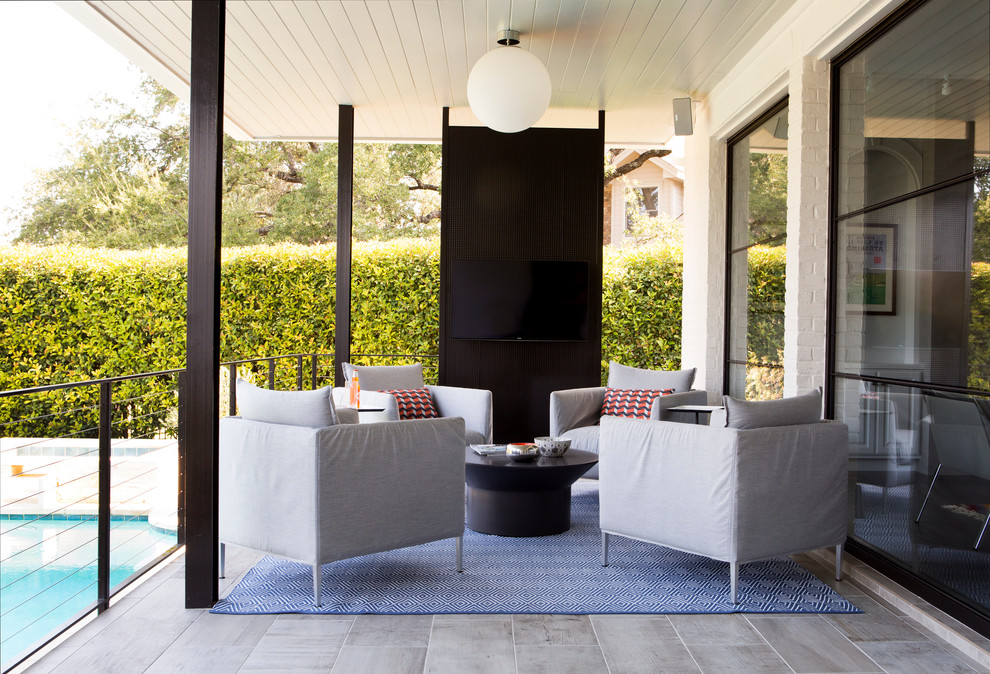 Photo of a large contemporary back patio in Austin with a roof extension.