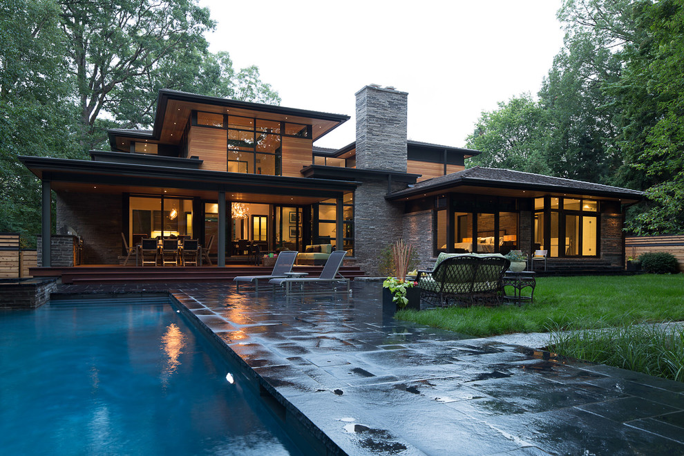Immagine di un grande patio o portico minimalista dietro casa con pavimentazioni in pietra naturale e nessuna copertura