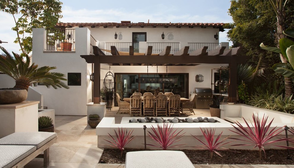 Foto di un grande patio o portico mediterraneo dietro casa con un focolare, pavimentazioni in pietra naturale e una pergola