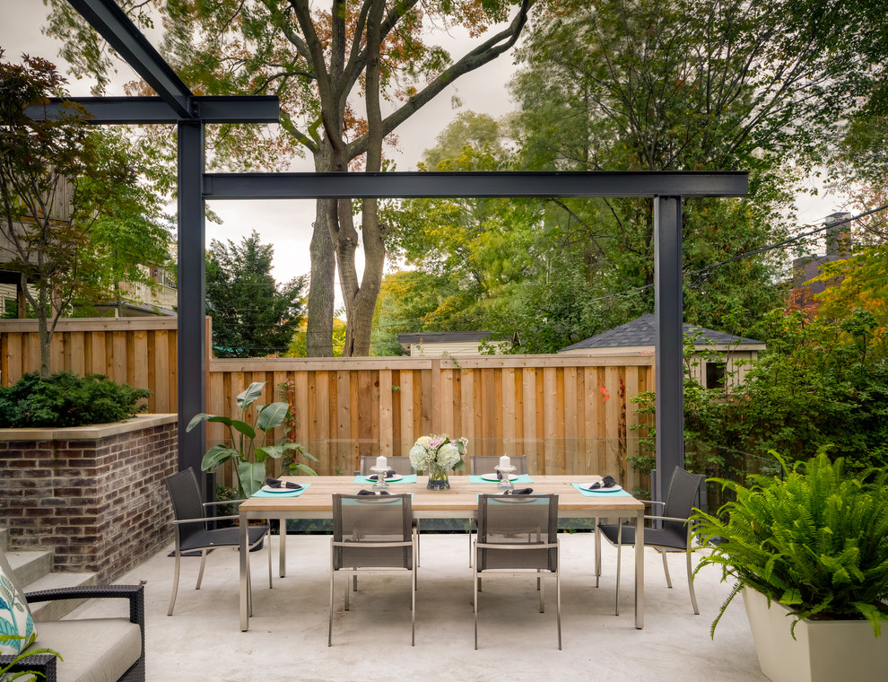Inspiration for a contemporary backyard patio fountain remodel in Toronto with a pergola