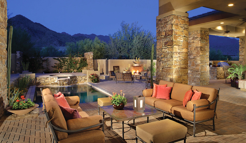 Inspiration for a mid-sized southwestern backyard brick patio remodel in Phoenix with a fire pit and no cover