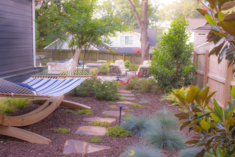 Imagen de patio de estilo americano grande sin cubierta en patio trasero con brasero y adoquines de piedra natural