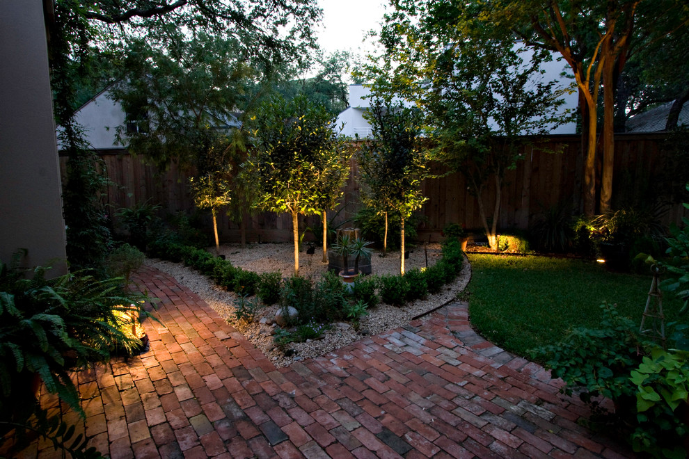Immagine di un giardino classico dietro casa con pavimentazioni in mattoni