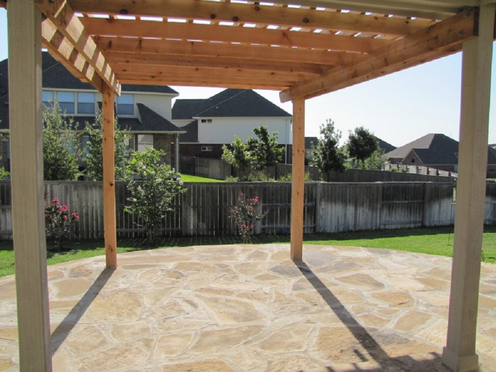 Cette photo montre une terrasse arrière tendance de taille moyenne avec des pavés en pierre naturelle et une pergola.