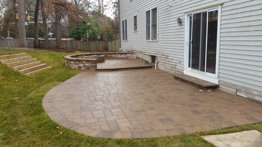 Large trendy backyard concrete paver patio photo in Baltimore with a fire pit