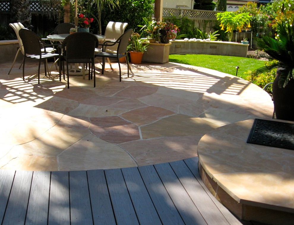 This is an example of a large classic back patio in San Francisco with natural stone paving and no cover.