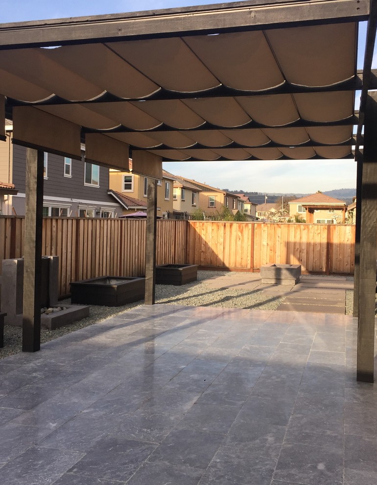 Foto di un patio o portico tradizionale di medie dimensioni e dietro casa con una pergola, un focolare e pavimentazioni in cemento