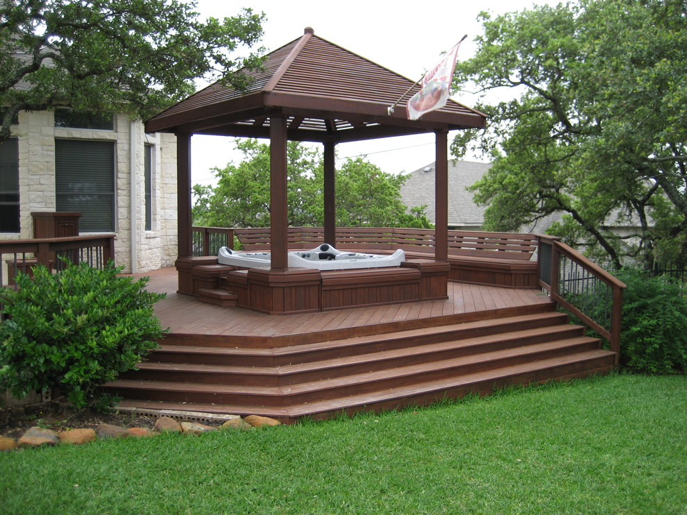 Example of a large trendy backyard patio fountain design in Austin with decking and a pergola