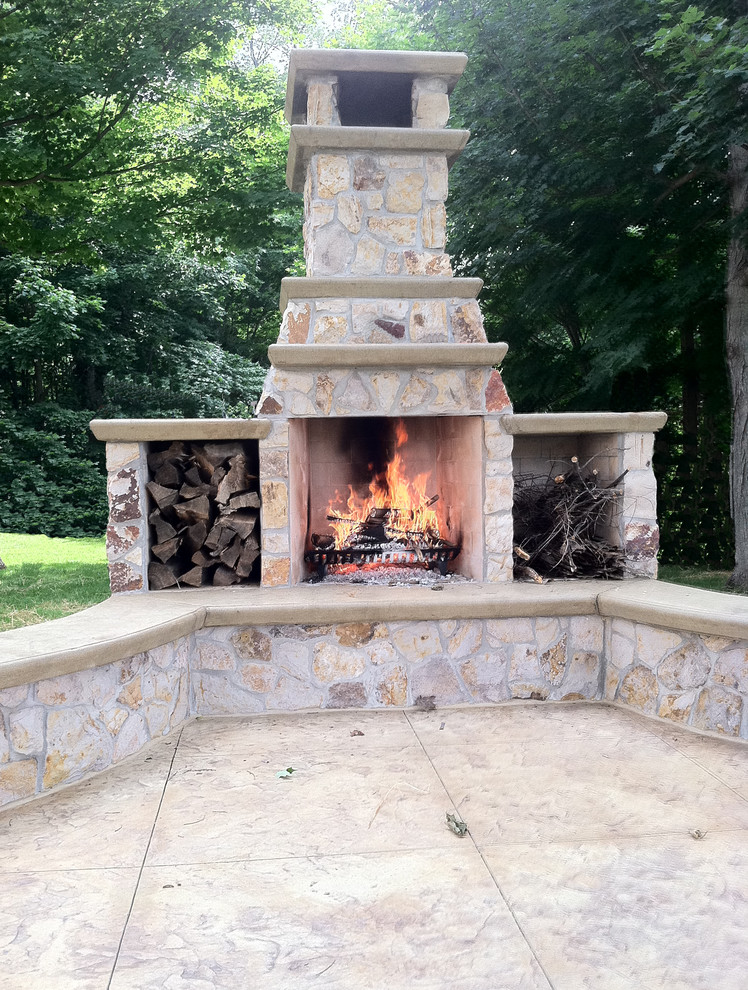 Inspiration for a huge modern backyard stamped concrete patio remodel in Indianapolis with a fire pit