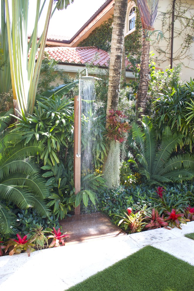 Bild på en mellanstor tropisk uteplats på baksidan av huset, med utedusch och marksten i betong
