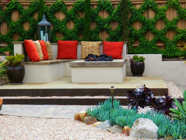 Пример оригинального дизайна: маленький двор на заднем дворе в средиземноморском стиле с местом для костра и покрытием из каменной брусчатки без защиты от солнца для на участке и в саду