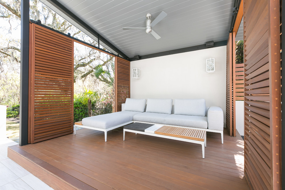 Idee per un grande patio o portico minimal davanti casa con piastrelle e un gazebo o capanno