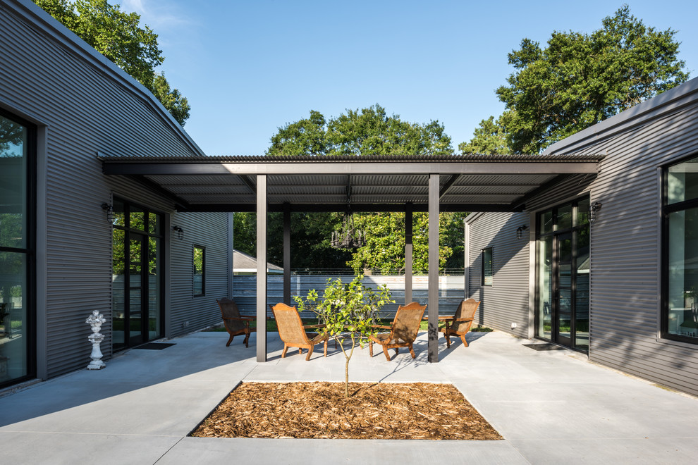 Idee per un patio o portico industriale nel cortile laterale con lastre di cemento