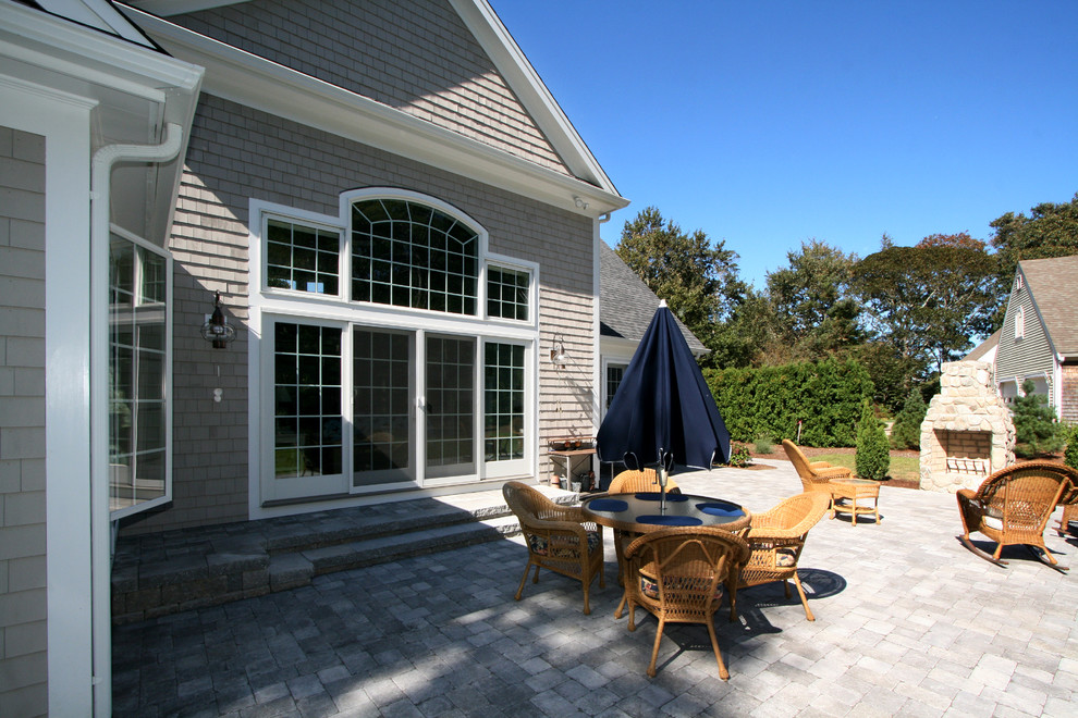 This is an example of a back patio in Boston with a fire feature and concrete paving.