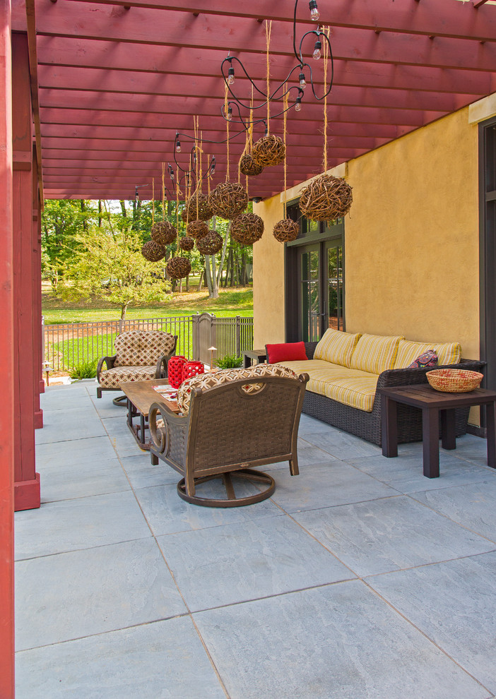 Пример оригинального дизайна: большой двор на заднем дворе в стиле неоклассика (современная классика) с местом для костра, покрытием из декоративного бетона и навесом