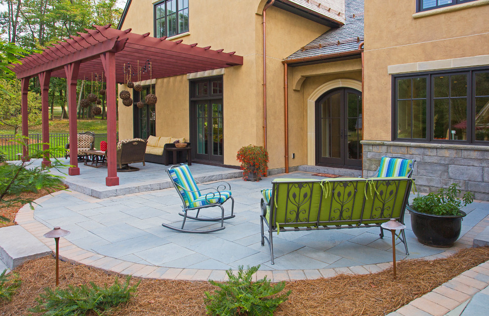 Example of a large transitional backyard stamped concrete patio design in Other with a fire pit and a roof extension