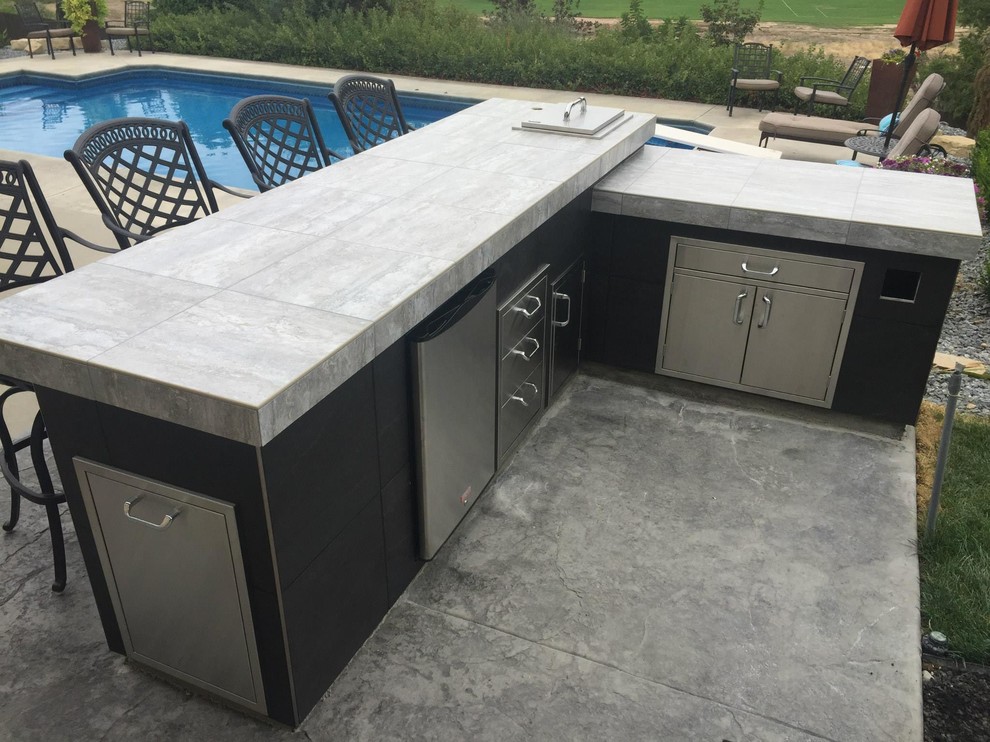 Photo of a medium sized classic back patio in Boise with an outdoor kitchen, concrete paving and a pergola.