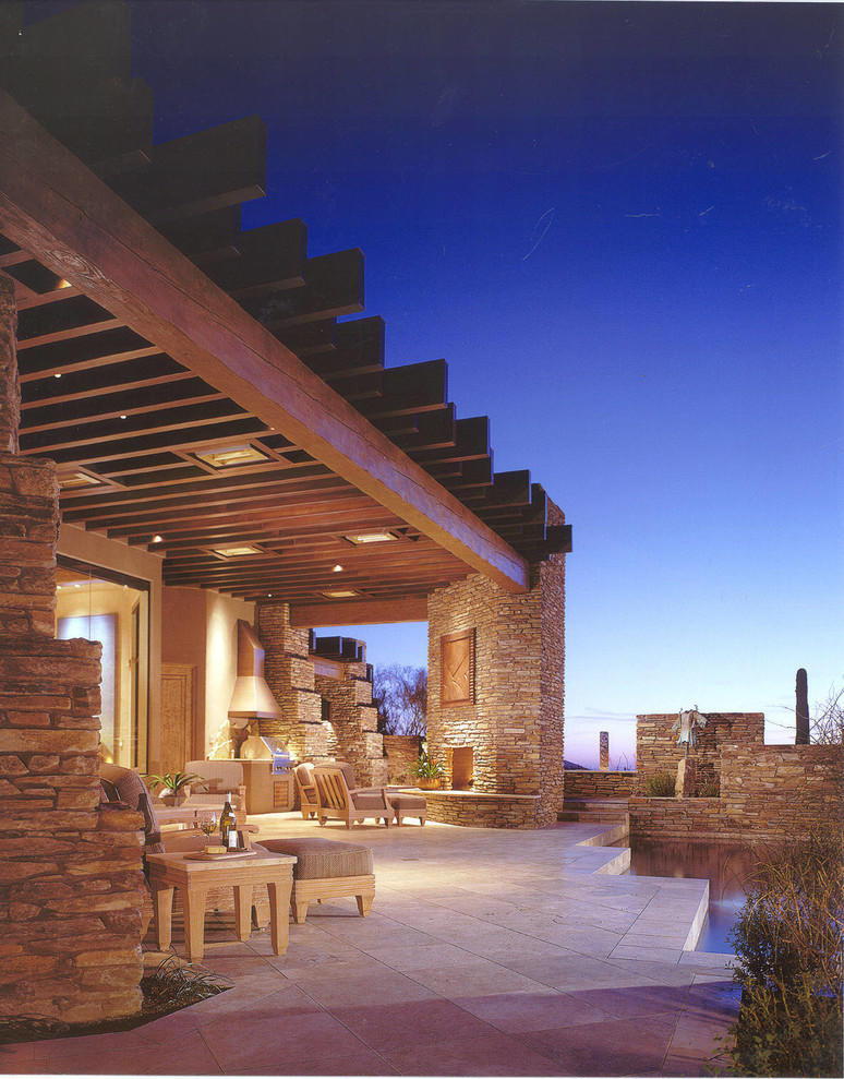 Immagine di un grande patio o portico american style dietro casa con un focolare e un tetto a sbalzo