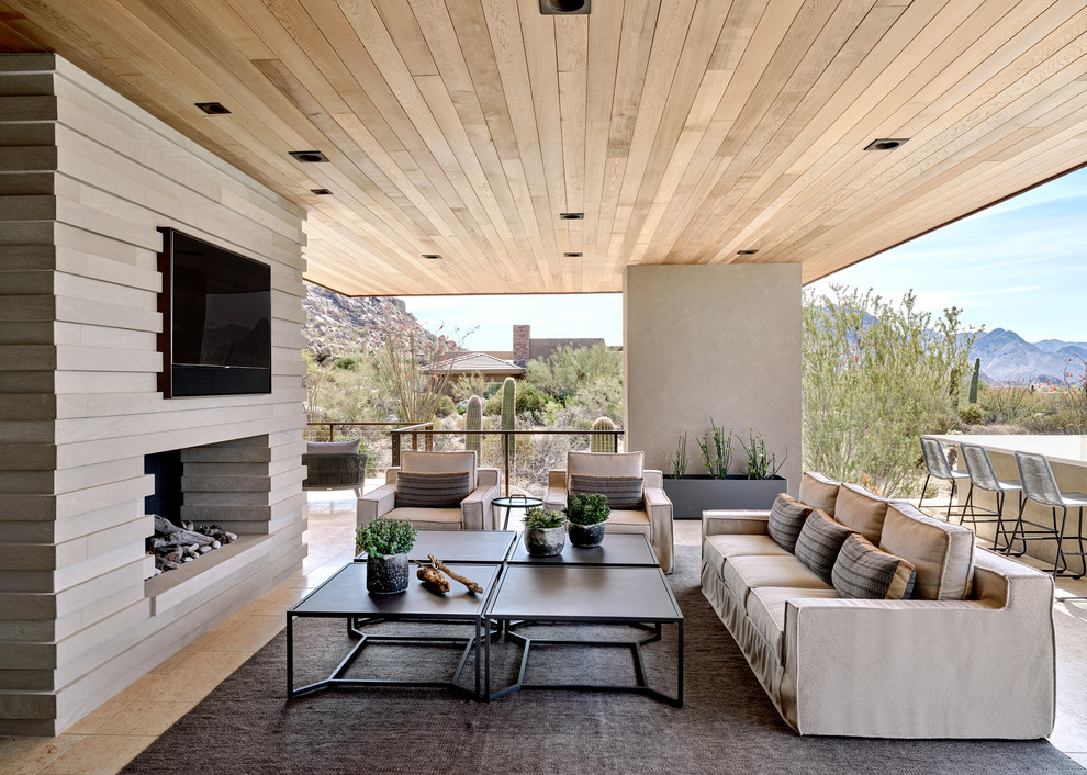 フェニックスにあるラグジュアリーな広いサンタフェスタイルのおしゃれな裏庭のテラス (屋外暖炉、張り出し屋根、タイル敷き) の写真