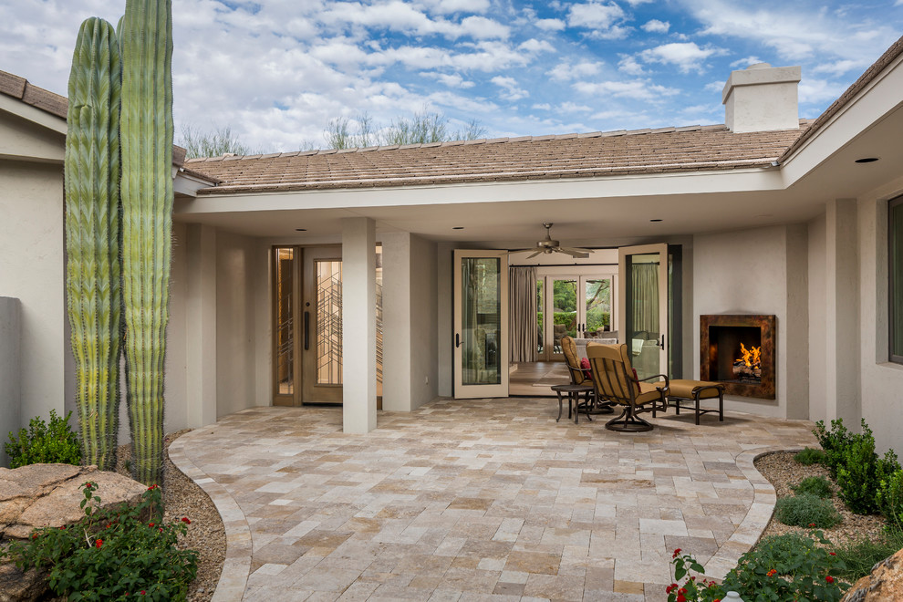 Inspiration for a mid-sized contemporary courtyard stone patio remodel in Phoenix with a fire pit and a roof extension