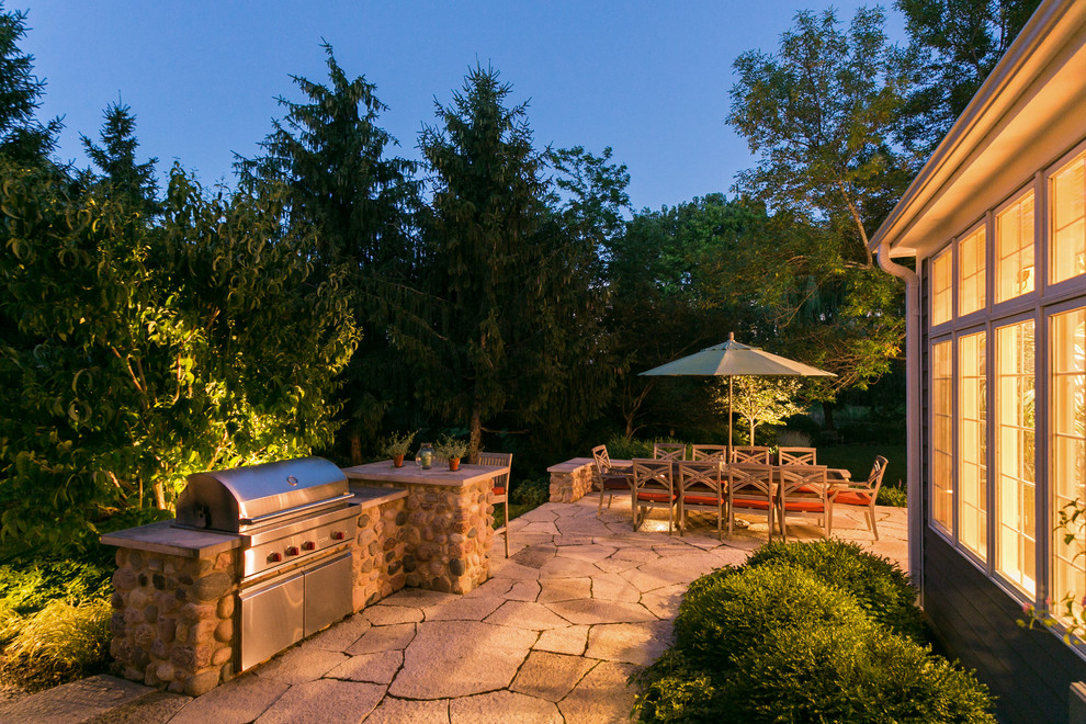 Modelo de patio clásico renovado grande sin cubierta en patio trasero con cocina exterior y adoquines de piedra natural