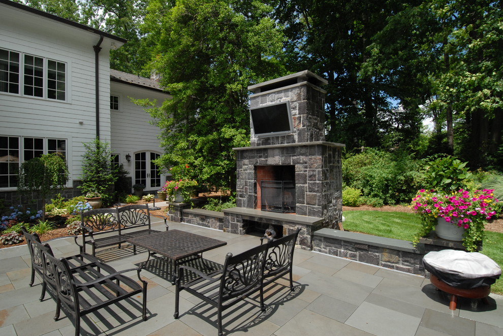 Idee per un ampio patio o portico vittoriano dietro casa con un focolare, pavimentazioni in pietra naturale e nessuna copertura