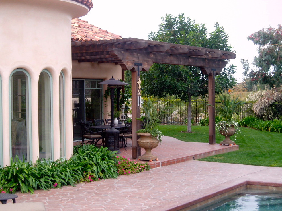 Patio - mediterranean backyard patio idea in San Diego with a fireplace and a pergola