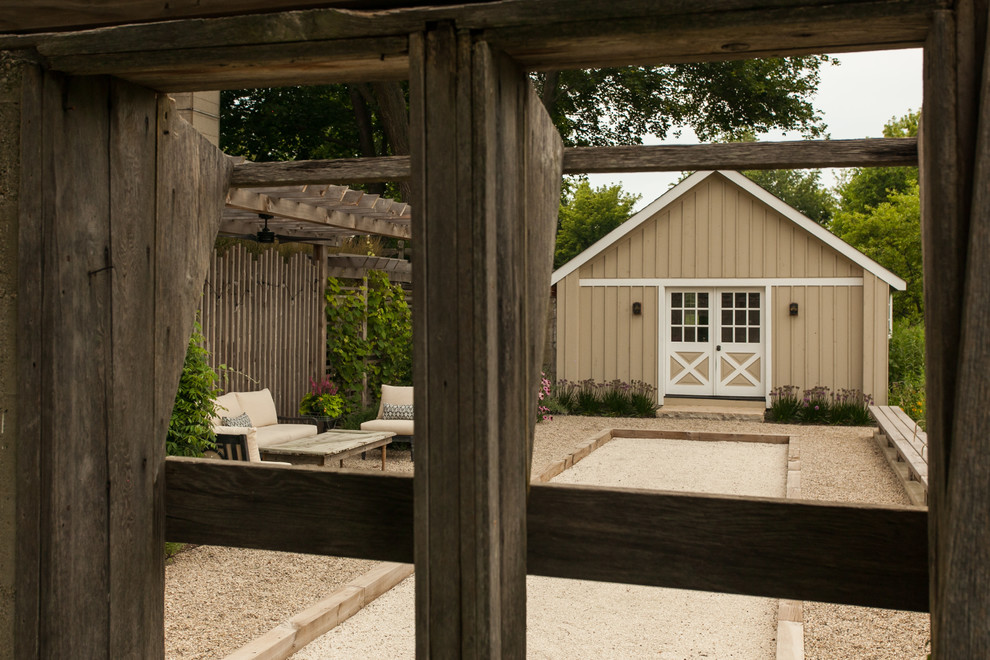 Photo of a medium sized rural side patio in Chicago with gravel and a pergola.