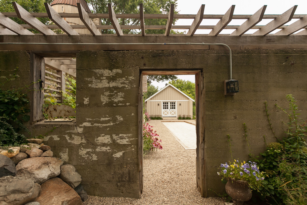 Exemple d'une terrasse latérale nature de taille moyenne avec du gravier et une pergola.