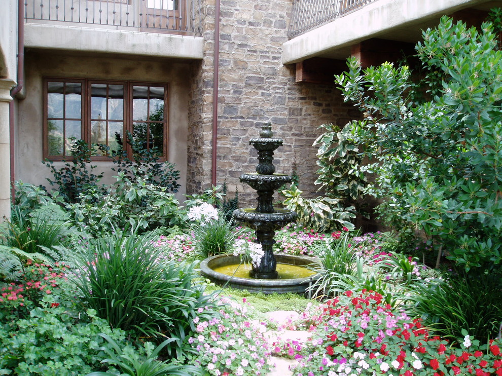 На фото: двор на внутреннем дворе в средиземноморском стиле с фонтаном