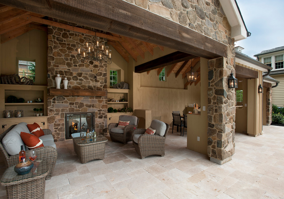 Cette image montre une terrasse traditionnelle avec un foyer extérieur et une extension de toiture.