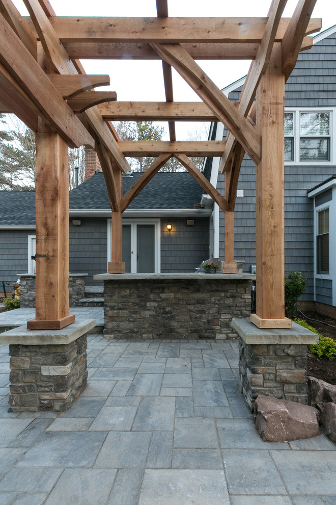 Cette photo montre une terrasse arrière nature de taille moyenne avec une cuisine d'été, des pavés en béton et une pergola.