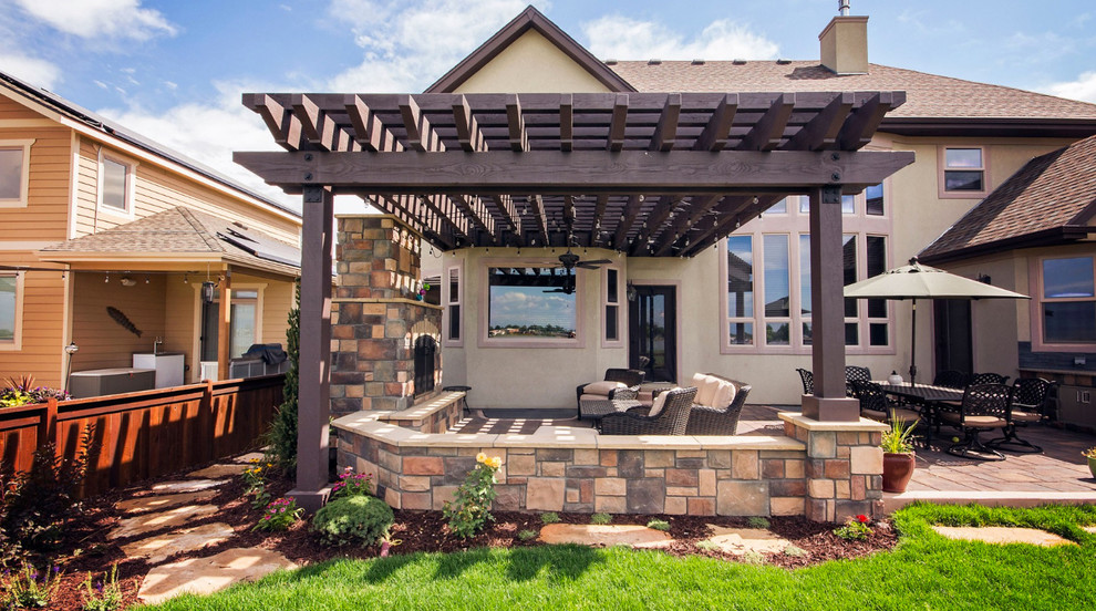 Mid-sized tuscan backyard concrete paver patio photo in Denver with a pergola and a fireplace
