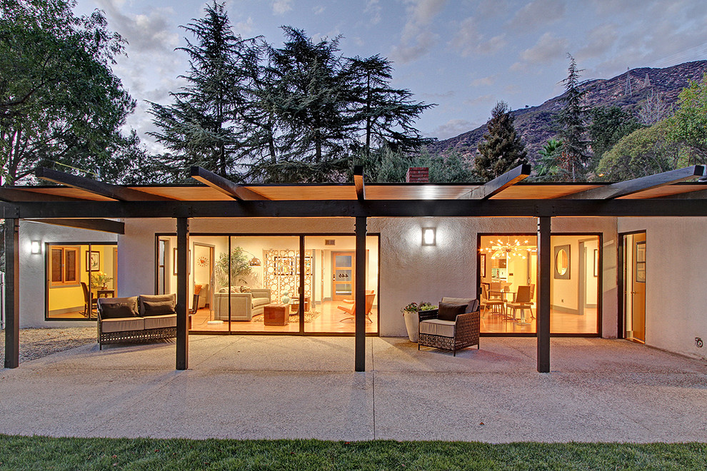 Ispirazione per un patio o portico moderno dietro casa e di medie dimensioni con una pergola e graniglia di granito