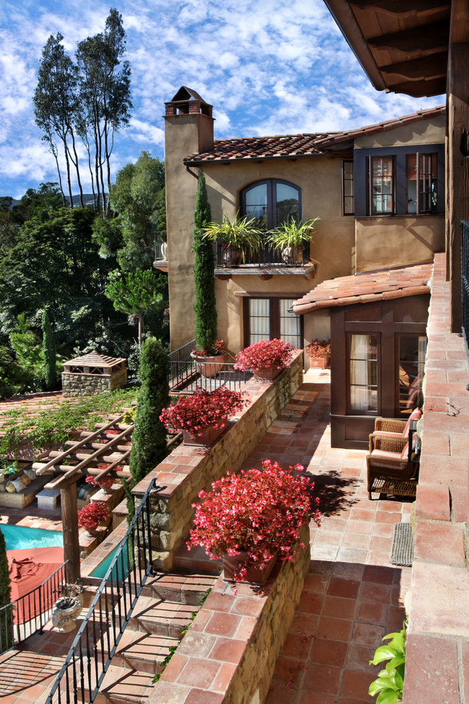 Inspiration for an expansive mediterranean back patio in Orange County with natural stone paving and a water feature.
