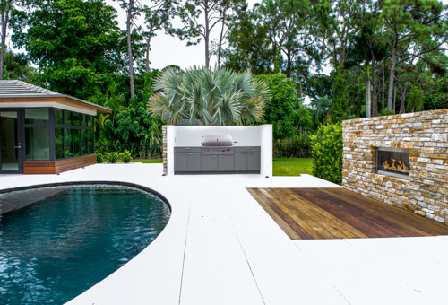 This is an example of a medium sized contemporary back patio in Miami with an outdoor kitchen, concrete slabs and a gazebo.
