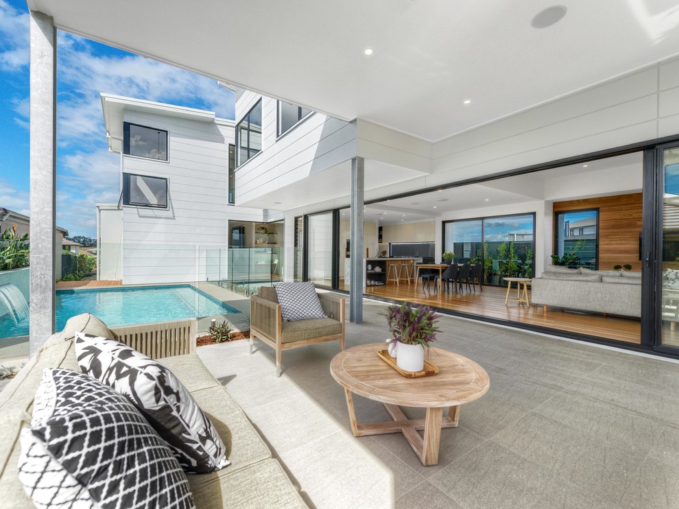 Moderner Patio hinter dem Haus mit Betonboden und Markisen in Brisbane