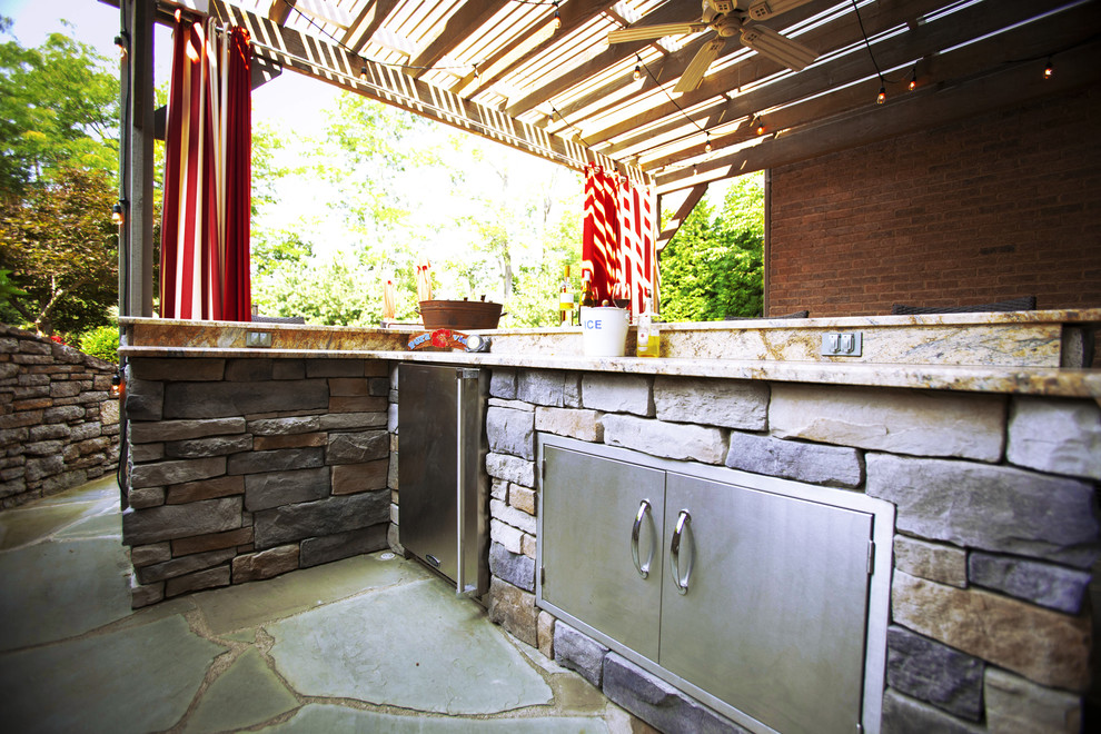 Foto de patio actual con cocina exterior y pérgola