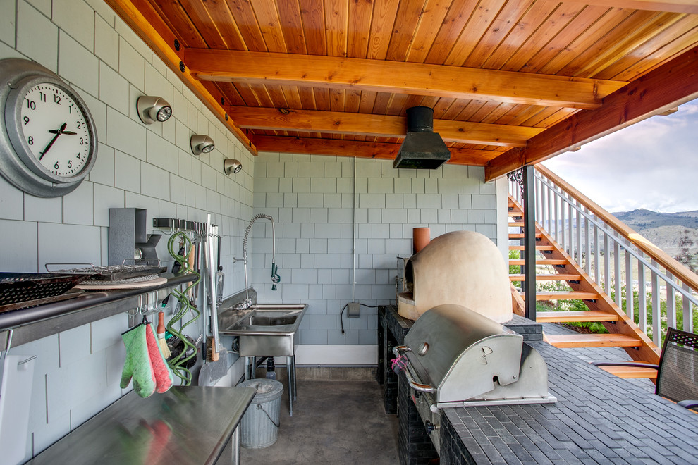 На фото: двор в стиле кантри с покрытием из бетонных плит, навесом и зоной барбекю