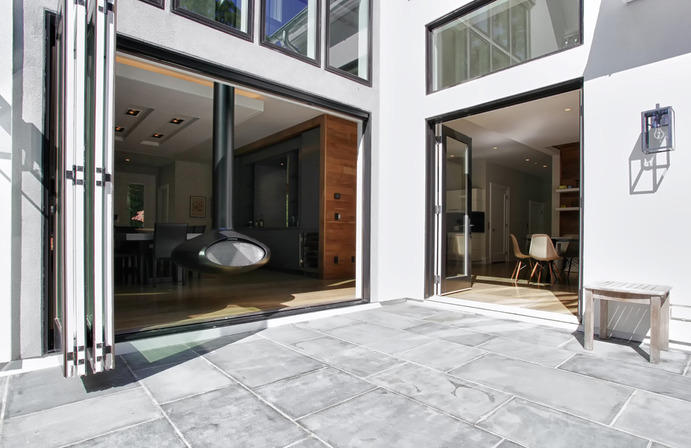 Réalisation d'une terrasse arrière minimaliste de taille moyenne avec un foyer extérieur et aucune couverture.