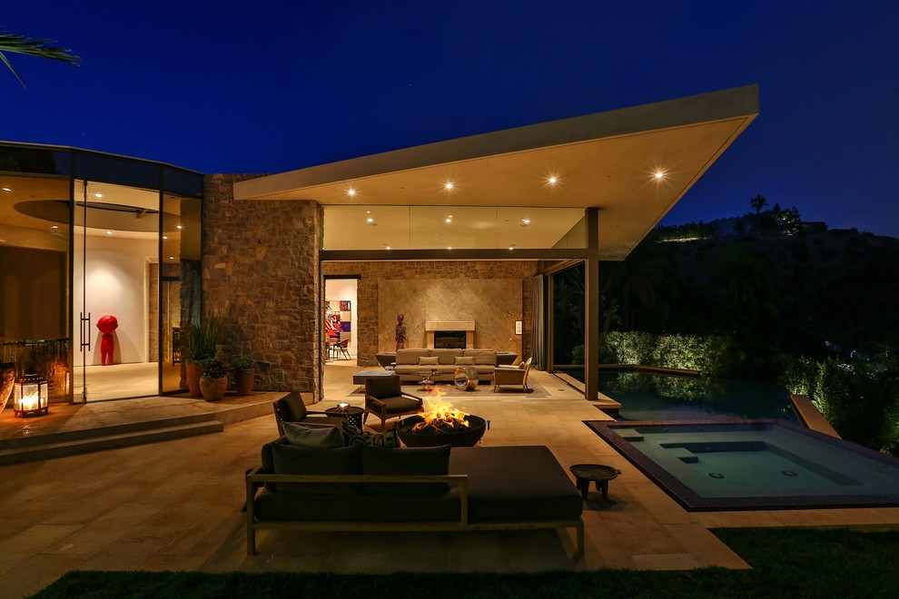 Inspiration pour une très grande terrasse avant design avec un foyer extérieur, des pavés en pierre naturelle et aucune couverture.