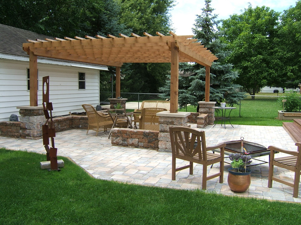Inspiration for a mid-sized transitional backyard concrete paver patio fountain remodel in Grand Rapids with a pergola