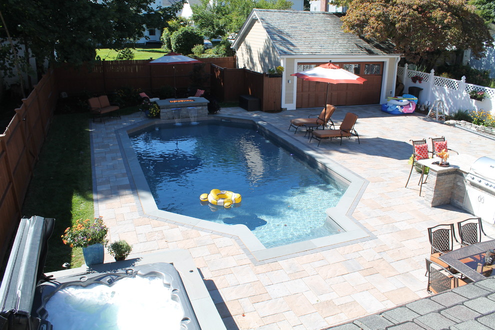 Modelo de piscina clásica renovada de tamaño medio en patio trasero con adoquines de hormigón