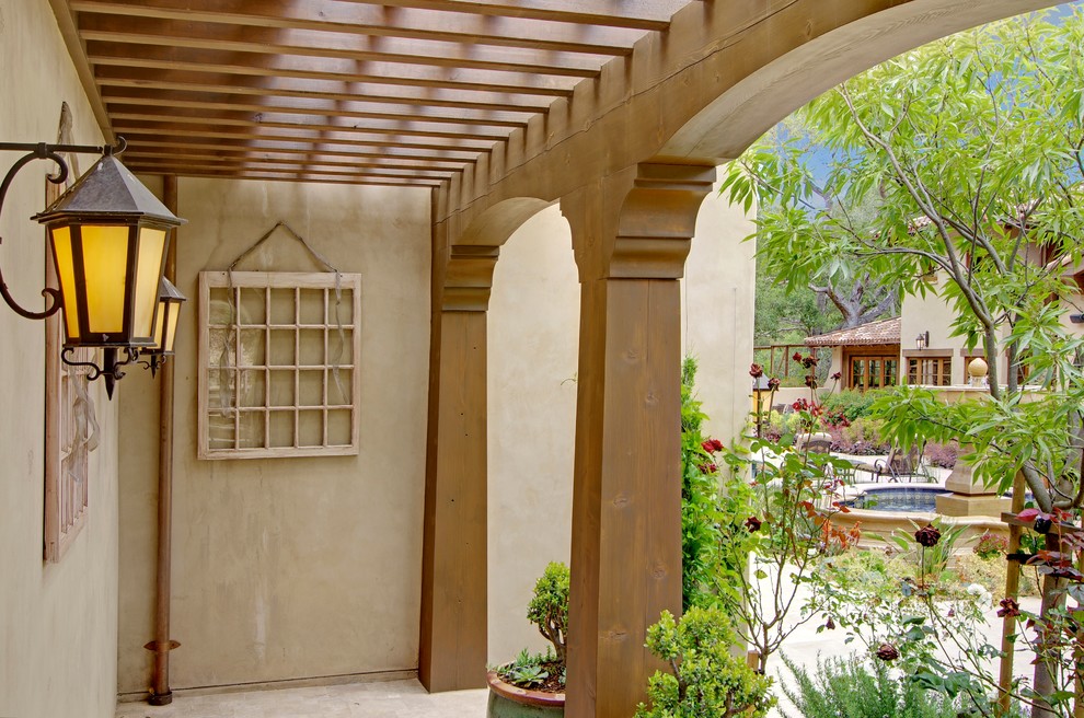 Diseño de patio mediterráneo de tamaño medio en patio trasero con jardín de macetas, losas de hormigón y pérgola