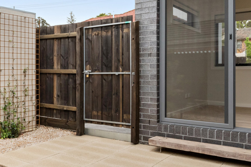 Immagine di un piccolo patio o portico industriale dietro casa con pavimentazioni in pietra naturale e nessuna copertura