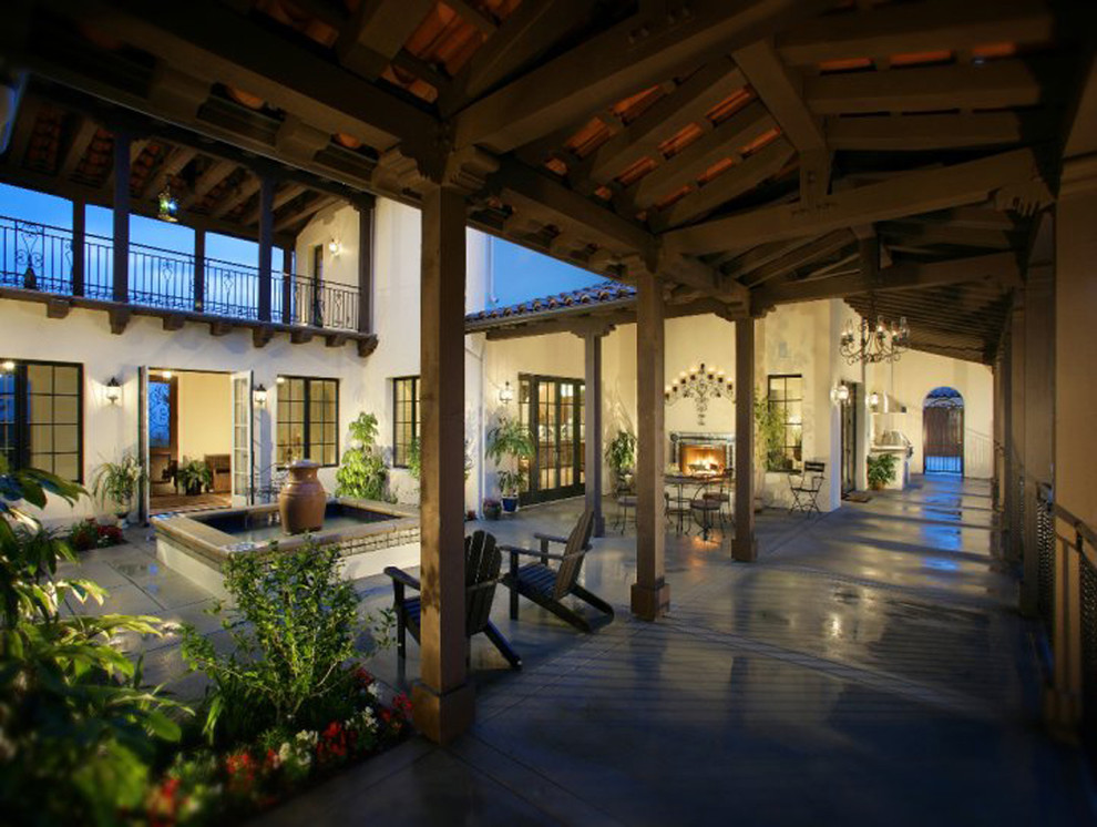 Diseño de patio mediterráneo en patio y anexo de casas con fuente y suelo de baldosas