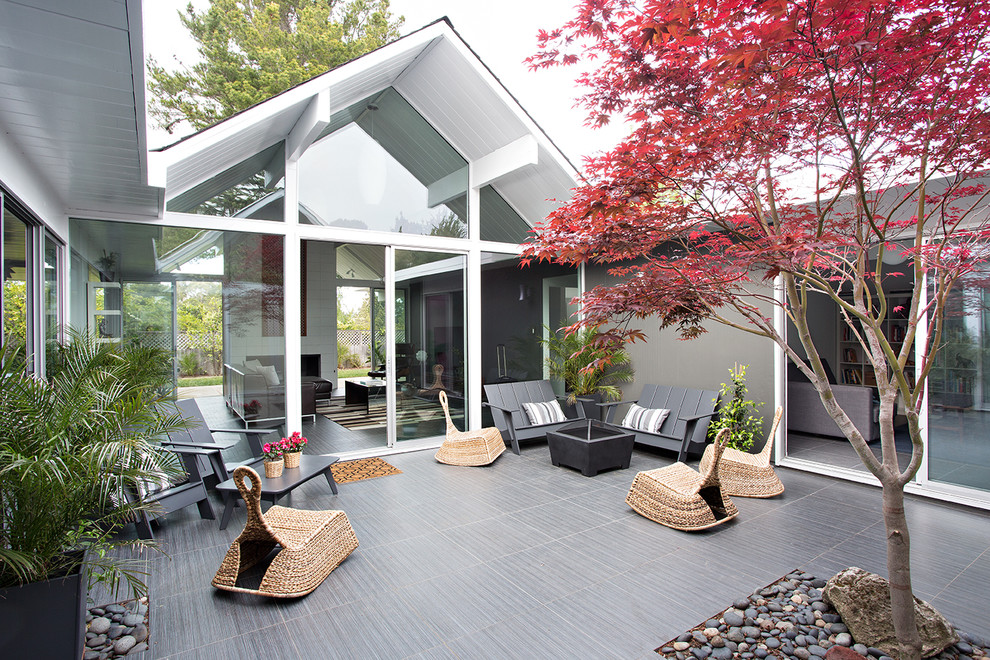 Стильный дизайн: двор на внутреннем дворе в стиле ретро с покрытием из плитки без защиты от солнца - последний тренд